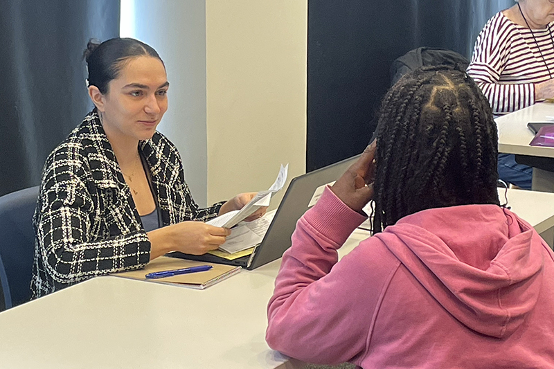 UD student Victoria Groome meets with a client at Woodlawn Library as part of the Volunteer Income Tax Assistance Program.