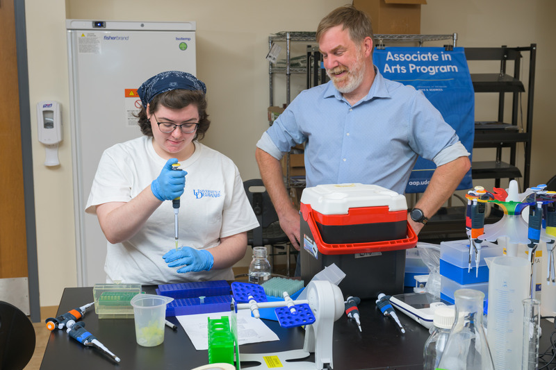 Haverly prepares to extract pollen from honey samples in order to study the DNA, while Dan McDevit, associate professor, looks on.