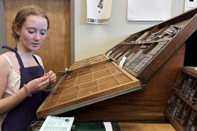 Cami Zabowski selects letter tiles to use in the letterpress during the capstone course ENGL480: From Ink to AI: Literature in the Makerspace. 