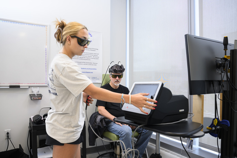 Sara Penuela Rodriguez (left), an interdisciplinary neuroscience doctoral student, administers infrared laser light therapy as part of a blinded study investigating its potential to address Parkinson’s symptoms by improving cellular metabolism and increasing blood flow. Sara Penuela Rodriguez (left), an interdisciplinary neuroscience doctoral student, administers infrared laser light therapy as part of a blinded study investigating its potential to address Parkinson’s symptoms by improving cellular metabolism and increasing blood flow.