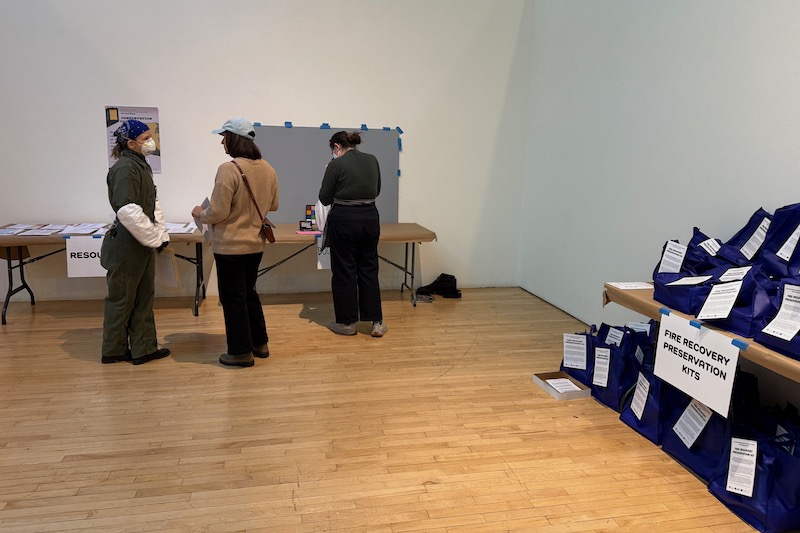 Art conservator Madison Brockman (far left) is among several University of Delaware alumni who have volunteered with the new Art Recovery Los Angeles (ARLA) project to help the Los Angeles community address damage from the January wildfires. In this photo, Brockman, a 2019 graduate of the Winterthur/University of Delaware Program in Art Conservation (WUDPAC), talks with a community member at a public clinic, letting her know about the free resources available to her. Art conservator Madison Brockman (far left) is among several University of Delaware alumni who have volunteered with the new Art Recovery Los Angeles (ARLA) project to help the Los Angeles community address damage from the January wildfires. In this photo, Brockman, a 2019 graduate of the Winterthur/University of Delaware Program in Art Conservation (WUDPAC), talks with a community member at a public clinic, letting her know about the free resources available to her.