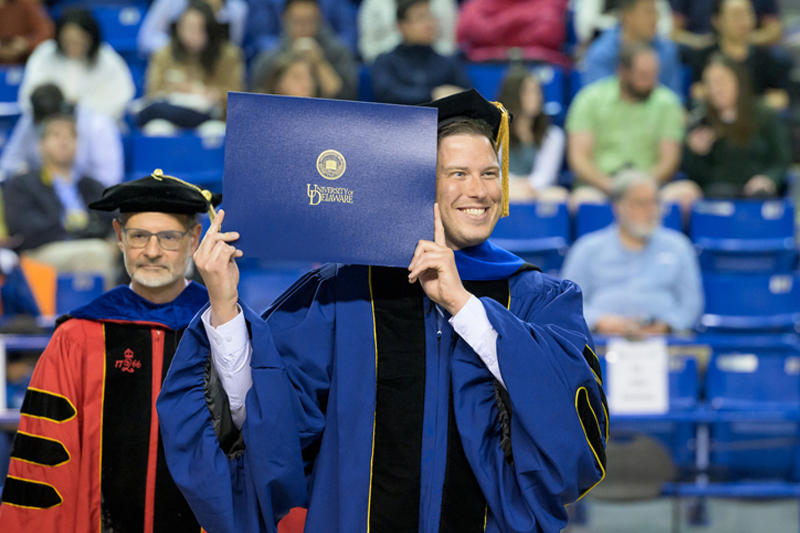 Adam Andressen happily holds up his diploma. Adam Andressen happily holds up his diploma.