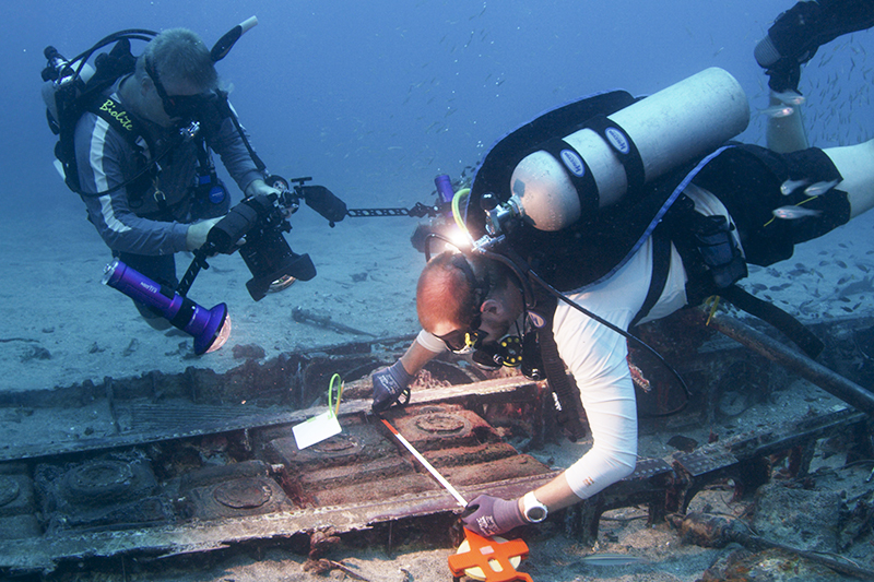 UD’s Mark Moline feels fortunate to be part of Project Recover’s effort to bring comfort and closure to families of missing crew members. Here, Scripps Institution of Oceanography’s Drew Pietruszka (right) measures the wing of a P-39 aircraft while Moline photographs the work. UD’s Mark Moline feels fortunate to be part of Project Recover’s effort to bring comfort and closure to families of missing crew members. Here, Scripps Institution of Oceanography’s Drew Pietruszka (right) measures the wing of a P-39 aircraft while Moline photographs the work.