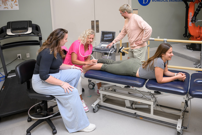 Karin Grävare Silbernagel performs an ultrasound of Madeleine Krotine’s Achilles tendon, while Stephanie Cone and Andy Smith observe.