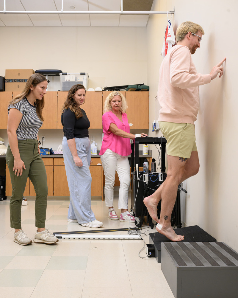 Andy Smith performs calf raises as Madeleine Krotine, Stephanie Cone and Karin Grävare Silbernagel look on. 