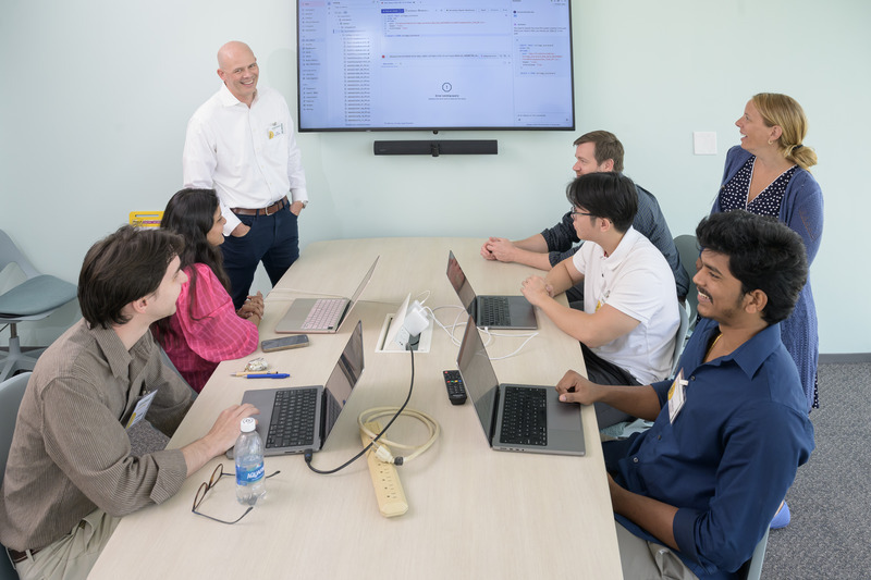 Mentors from Sallie Mae (pictured standing), including Andrew DeAngelo, head of credit risk and model risk governance, and Michele Mullowney, head of risk administration and governance, collaborate with a UD student team.