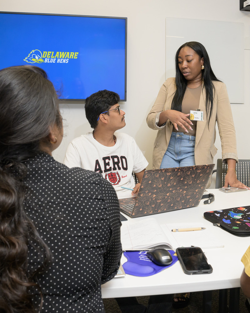 Joy Elias (pictured standing), customer engineer from Google, addressed student questions as a mentor at the hackathon. “AI can’t replace what humans bring to the table,” Elias said.