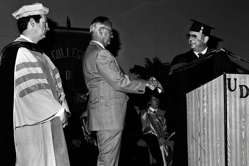 Jack R. Vinson congratulates James F. Kearns (class of 1950), who is being presented the Distinguished Alumnus Award, while R. Byron Pipes looks on. Photo from 1986.