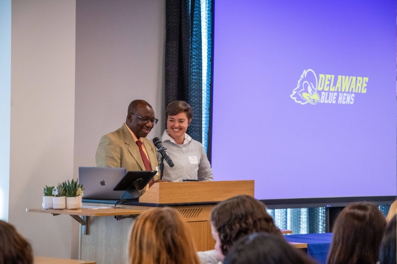 Oni-Eseleh (left) welcomes conference participants after an introduction from Hill (right). 