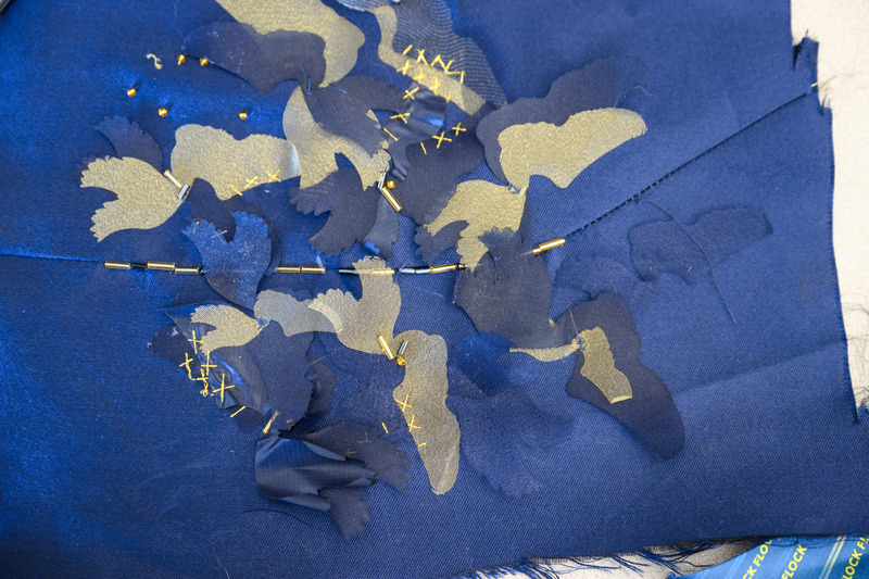 The laser-cut blue and gold sneakers that adorn Carlson’s jacket represent her love for running as well as UD’s 150 majors.