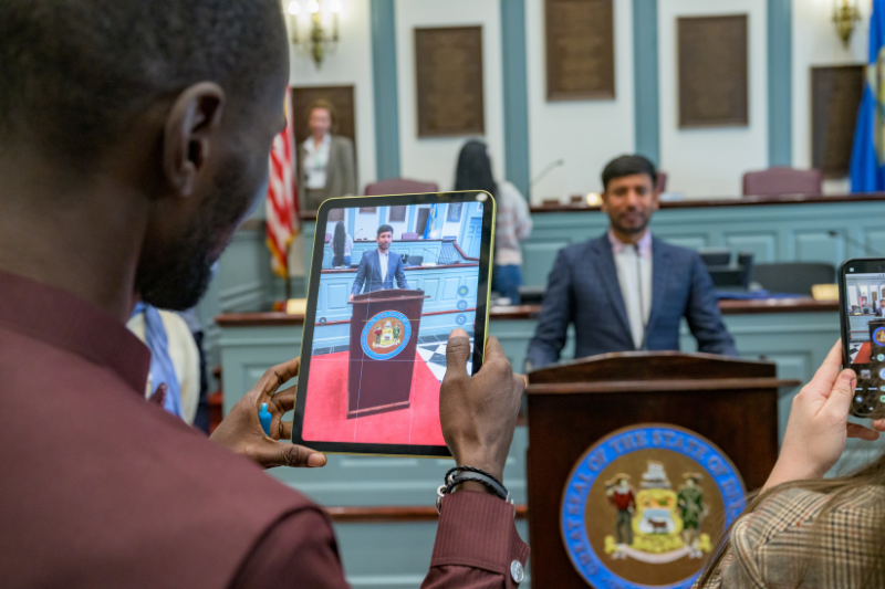 Bishnu Karki (right) has his photo taken at the podium in the House Chamber of Legislative Hall in Dover. 