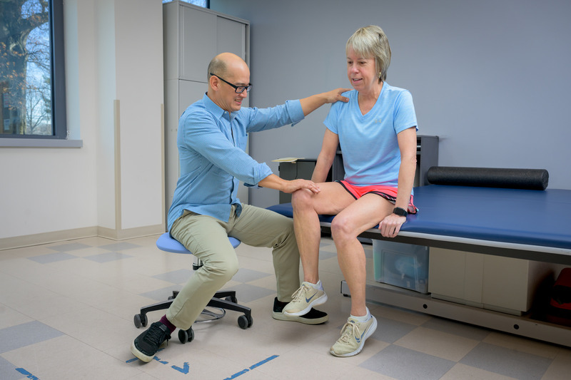 Laura Schmitt, who attended physical therapy for knee osteoarthritis for years, demonstrates a knee-strengthening exercise aimed at improving mobility with Daniel White, associate professor of physical therapy. 