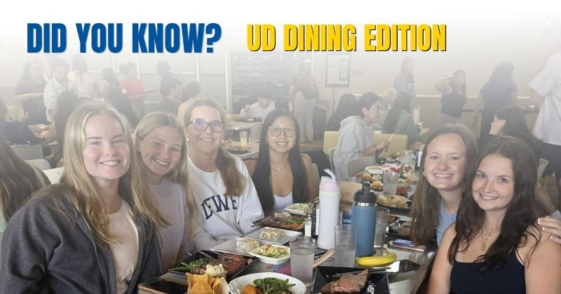 Students sitting at a table posing with food 