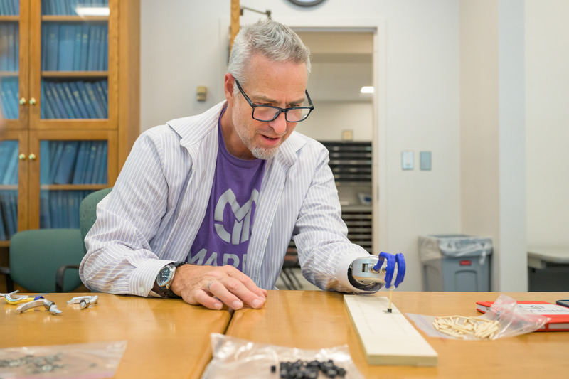 Darryl DuBre of Marins Inc. tests the students’ 3D-printed prosthetic hand prototype.