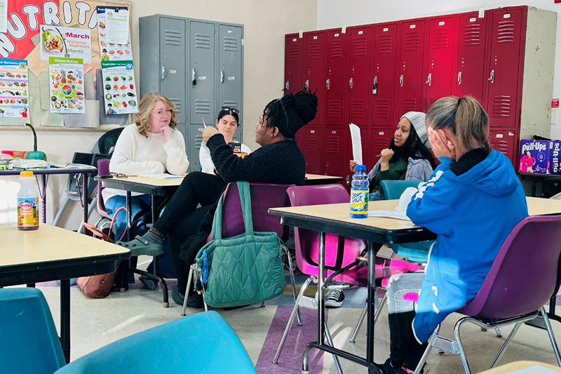 Holli Flanagan (left) works with participants in the YWCA Delaware’s expressive writing program