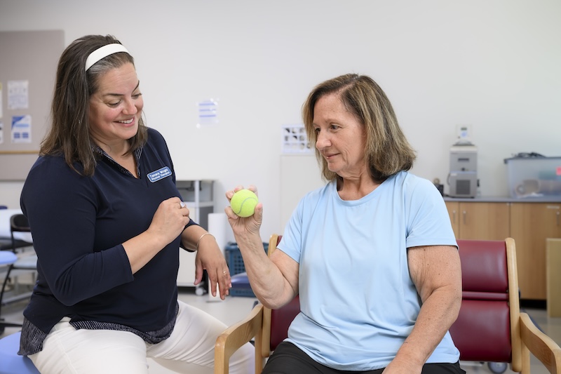 Stroke survivor Angie Pellerito works with research physical therapist Tamara Wright on an Upper Extremity Fugl-Meyer Assessment, which measures arm, wrist and hand movement. 