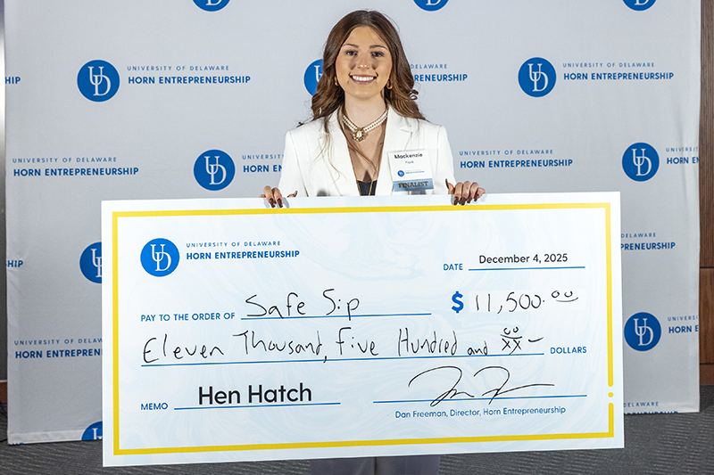 Mackenzie Frank, a junior entrepreneurship major, holds the top prize check after her company, SafeSip, was named the winner of Hen Hatch, the University of Delaware’s premier startup funding competition.