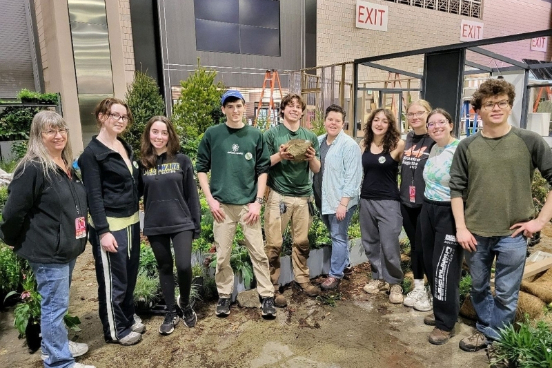 Members of the UD Flower Show Club pose for a photo during preparations for the 2025 Philadelphia Flower Show at the Pennsylvania Convention Center. The team won a gold medal for their exhibit, “Lab to Landscape.”