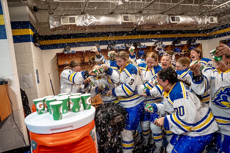The groundbreaking Division 1 women’s ice hockey team at the University of Delaware, seen here dumping water on Coach Allision Coomey after the first win of the season, has much to celebrate.