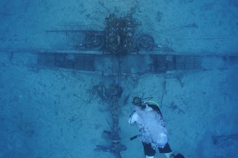 Deep sea diver with World War II wreckage