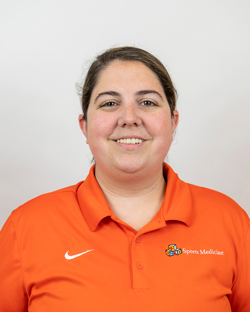 UDPT alumna Beth Ackerman wearing an orange shirt