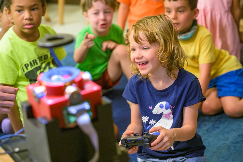 A young student uses a video game joystick to control microrobots during a demonstration led by UD researchers at the Early Learning Center. The researchers projected the tiny machines onto a screen, allowing students to watch the robots move as they took turns at the controls.