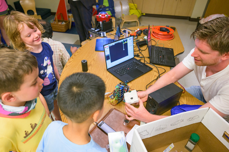 Rivas shows students iron filings during the ELC demonstration. For the researchers, the children’s fascination with magnets, light and tiny robots was a reminder of the curiosity that drives scientific discovery.