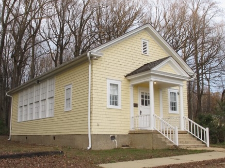 Exterior photo of the yellow and white Friendship School 202-C in Sussex County, Delaware