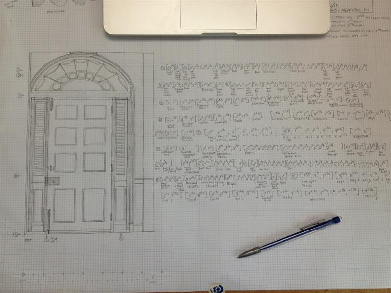 Photo of  a graduate students hand-drawn field notes of a doorway sketched in pencil on white graph paper while in the process of being converted to measured drawings in AutoCAD software