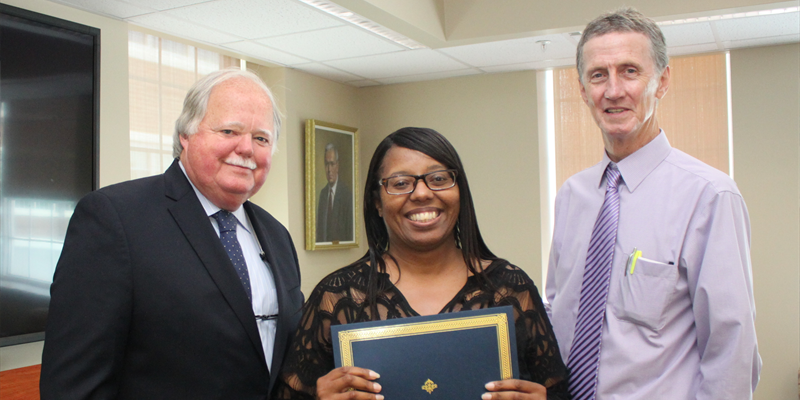 Portrait of Ed Freel (left) and Fran O'Malley (right) recognizing educator Lisa Swan for participation in the 2016 Democracy Project