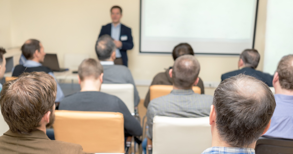 A group of adults watching a presentation.
