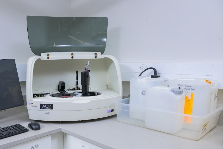 A small machine with shield flipped open to show the inside: the AQ2 Discrete Analyzer.