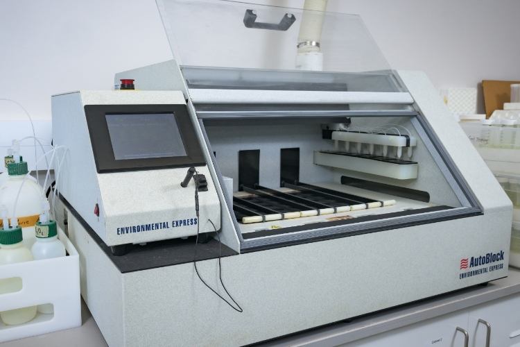 A quite large, older piece of tabletop equipment with sheild open so test samples can be places inside.