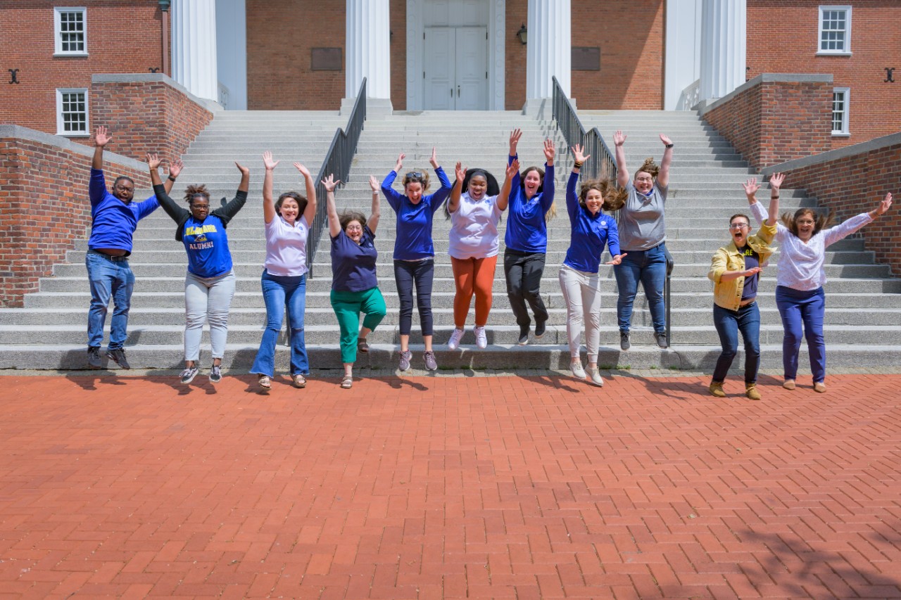 Advisors jumping in front of campus building