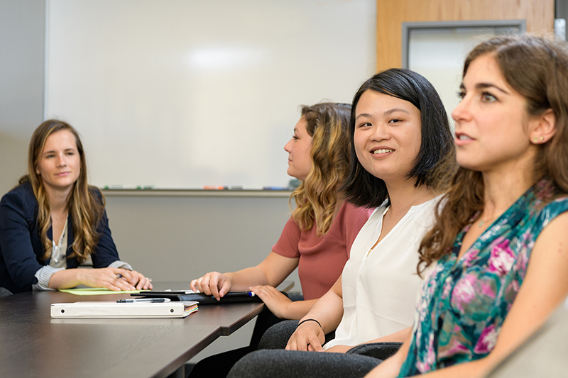 Four graduate students meet inside a conference room
