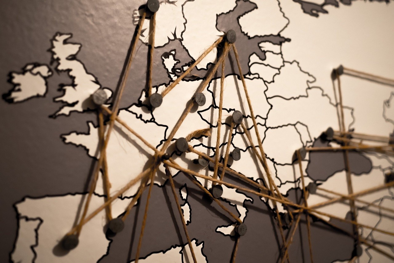 World map of Eurpean countries with tacks and strings plotting migration routes