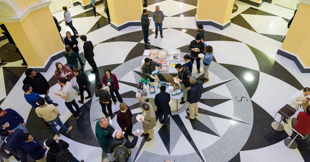An aierial view looking down at faculty and students congregating in the center circle in Gore for the Winter Research Symposium for the Department of Mathematical Sciences. 