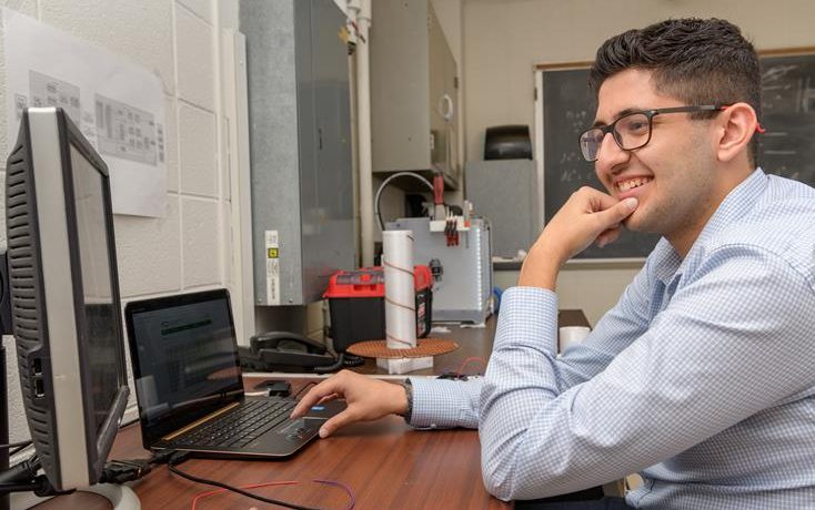 Photo of student ​Ahmad Jalal Al Tamini in a lab setting looking at computer