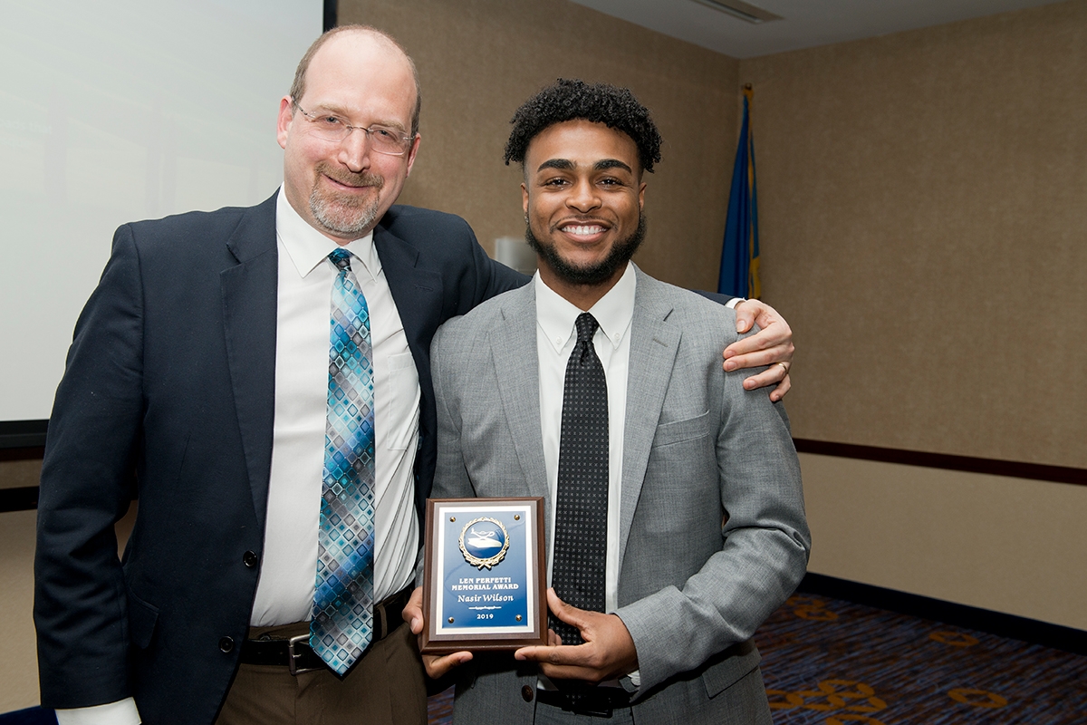 Professor Ben Fleury-Steiner present a plaque to University of Delaware senior Nasir Wilson during an annual awards banquet hosted by the Department of Sociology and Criminal Justice.