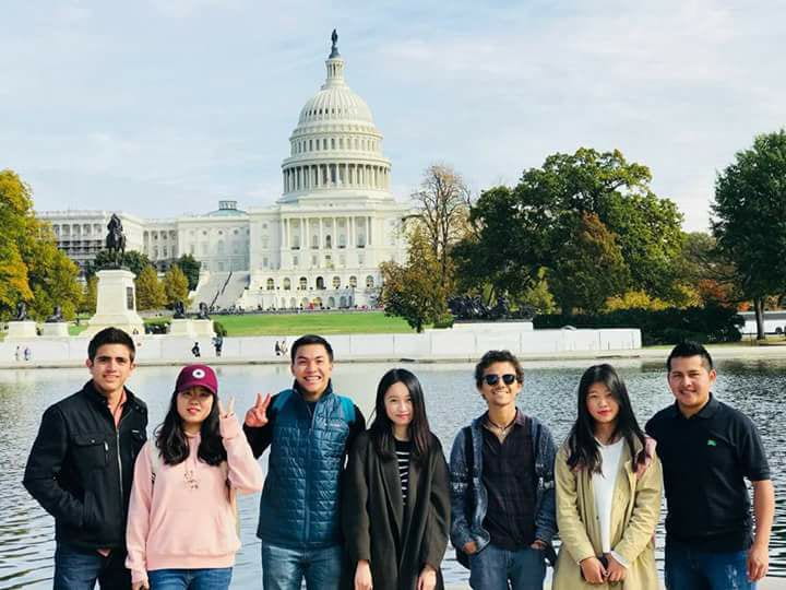 Seven college students stand in front of to the U.S. Capitol building in Washington, D.C.