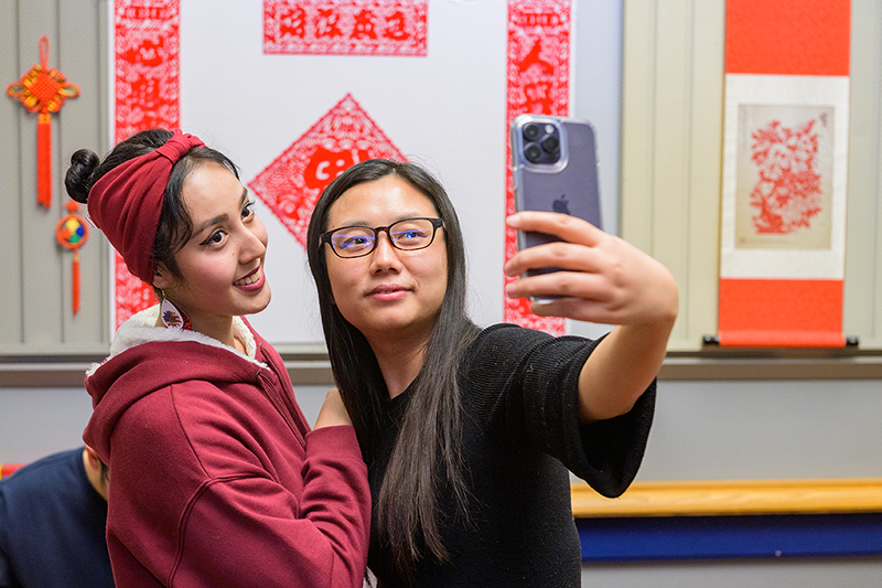 Two college students pose together for a selfie during an event at the University of Delaware.