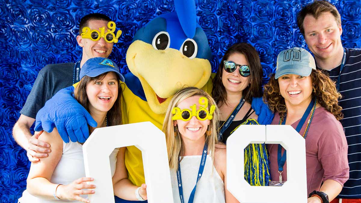A group of UD alumni posing with YouDee