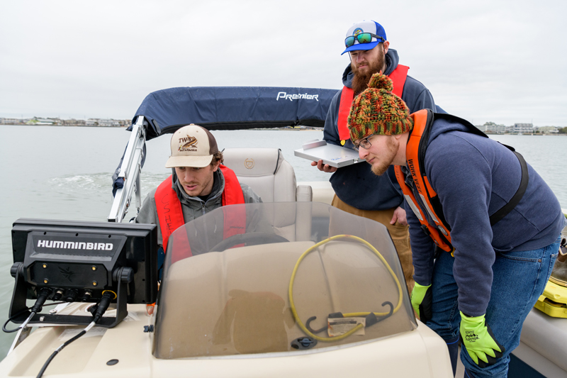 Volunteer using sonar to detect a derelict crab pot
