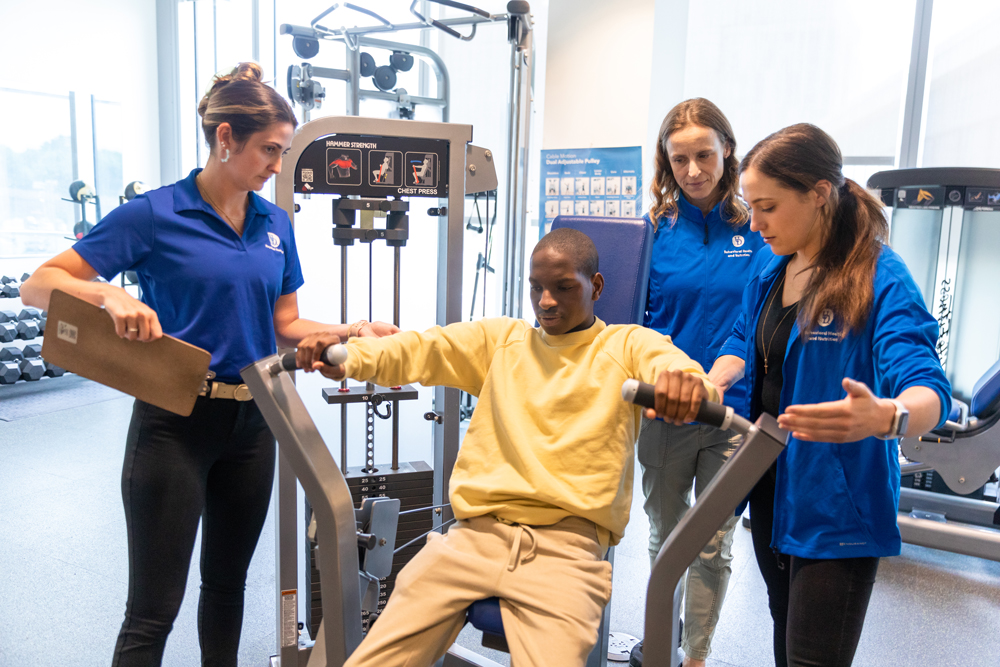 Health Behavior Science students working with an individual in the adapted fitness course