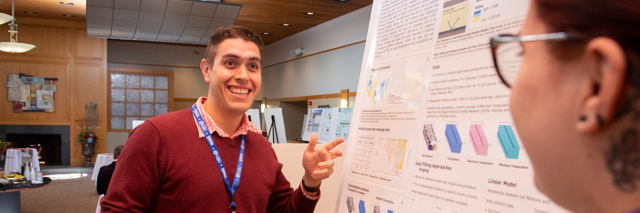 Graduate Student presenting their research in a poster session.