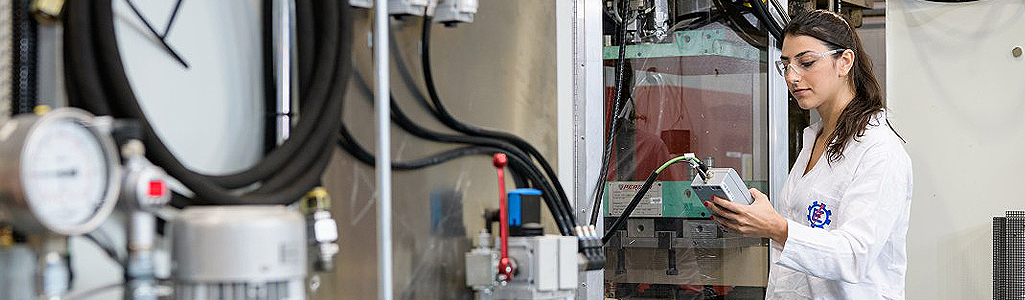 Researcher using high pressure resin transfer molding equipment.