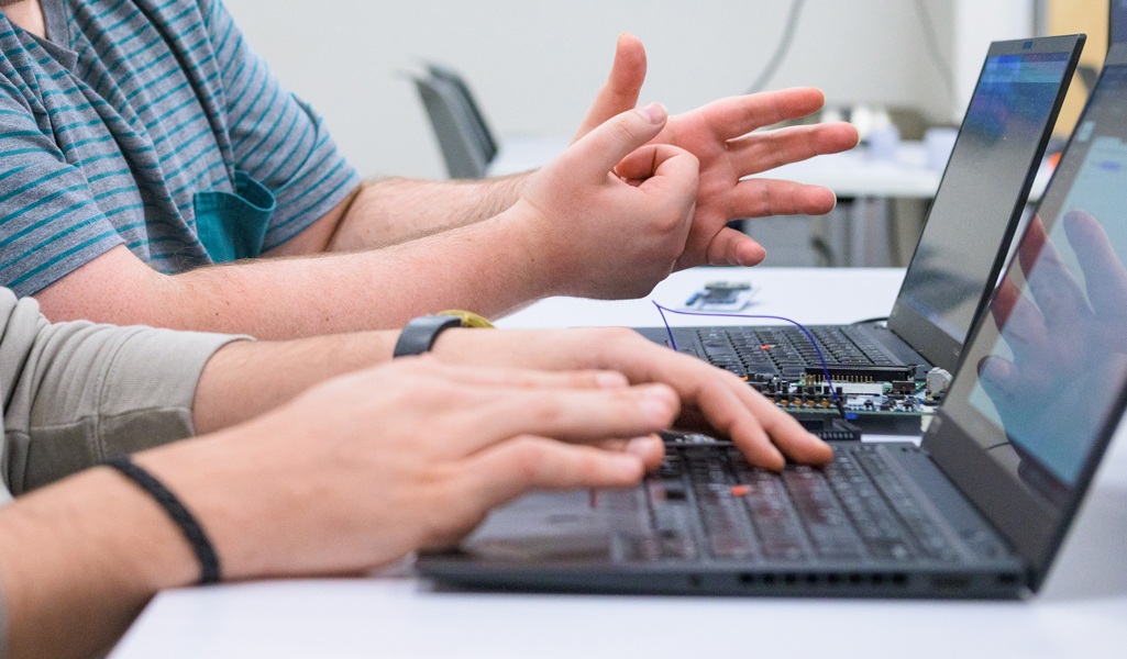 Hands typing on a laptop