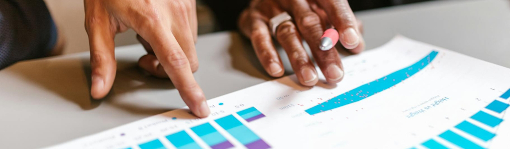 People reviewing graphs on paper.