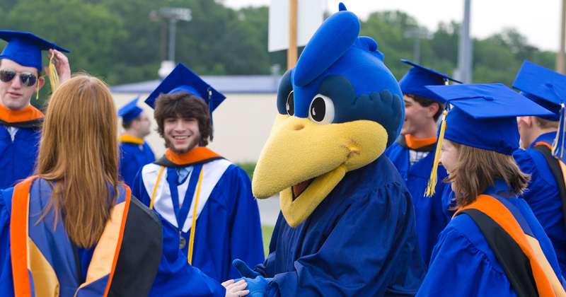 YoUDee with a group of students as they celebrate commencement.
