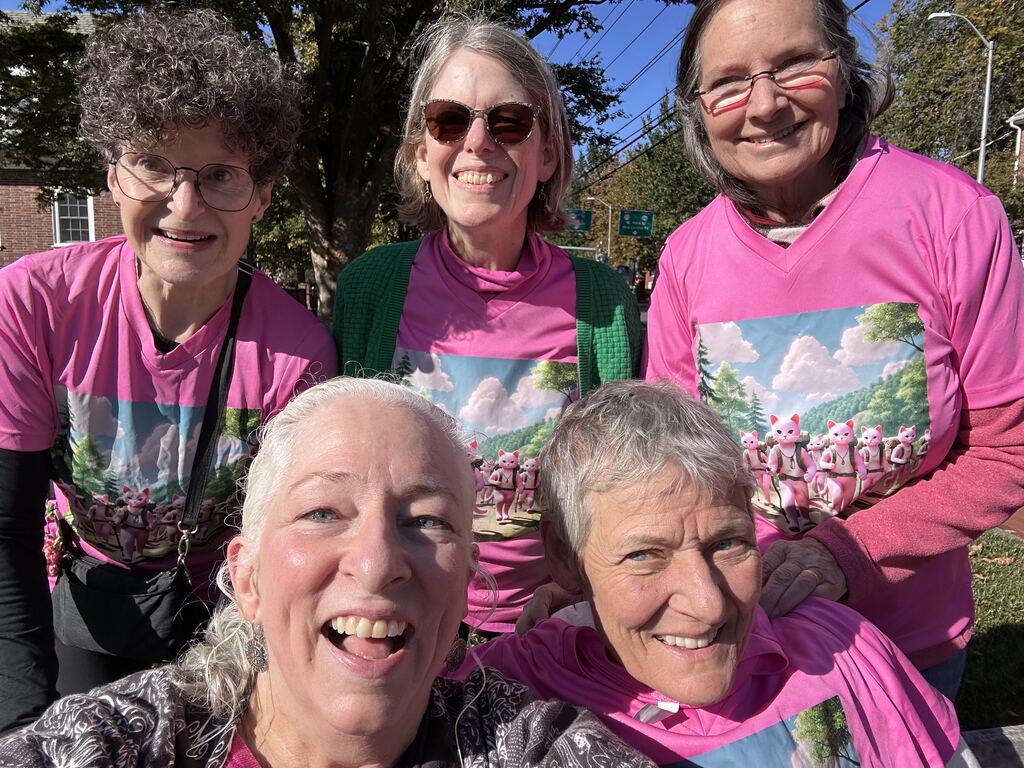 5 women in pink tshirts pose for a selfie